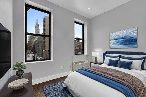 A bedroom with a large bed and a view of the city.